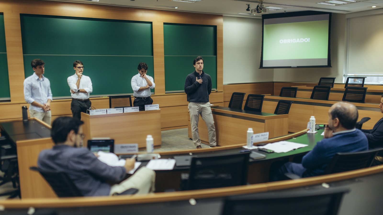 Banca de executivos e professores arguindo uma equipe durante a apresentação